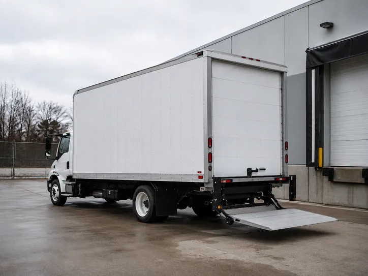 White box truck backed to a loading dock with its lift gate lowered